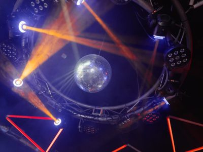 Vibrant nightclub scene with colorful lights and disco ball, creating a lively atmosphere.